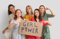 Five women holding a sign with the inscription "Girl Power"